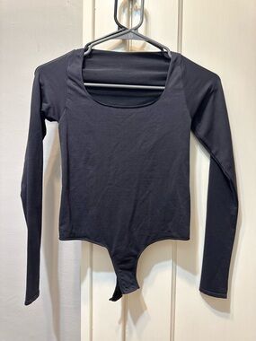 Skims Black Long-Sleeve Scoop Neck Bodysuit. Raw edge